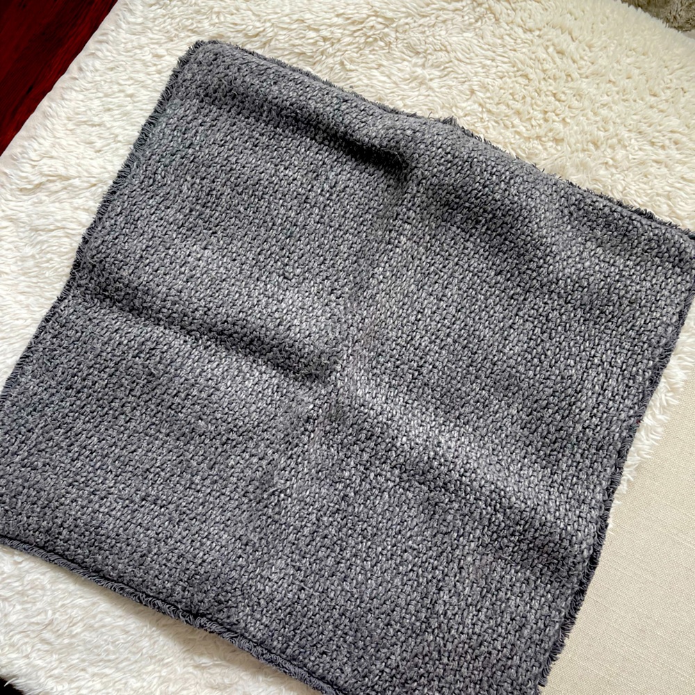 Pottery barn pillow grey blue color with fringed edges.